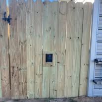 Wooden gate with a black keypad lock.