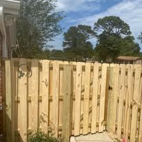Wooden fence in an outdoor setting, with a bright sky in the background.