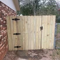 Wooden fence with black decorative hardware, adjacent to brick wall and metal fence.