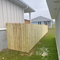 Wooden fence next to a house with a light-colored exterior.