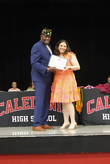 Robert Bishop standing on a stage presenting American Legion Scholarship