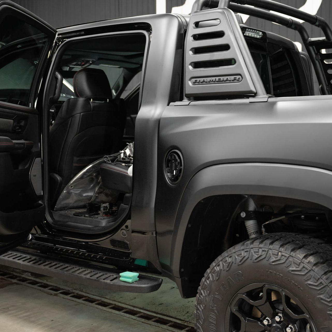 Black pickup truck with open door, showing interior and exterior details.