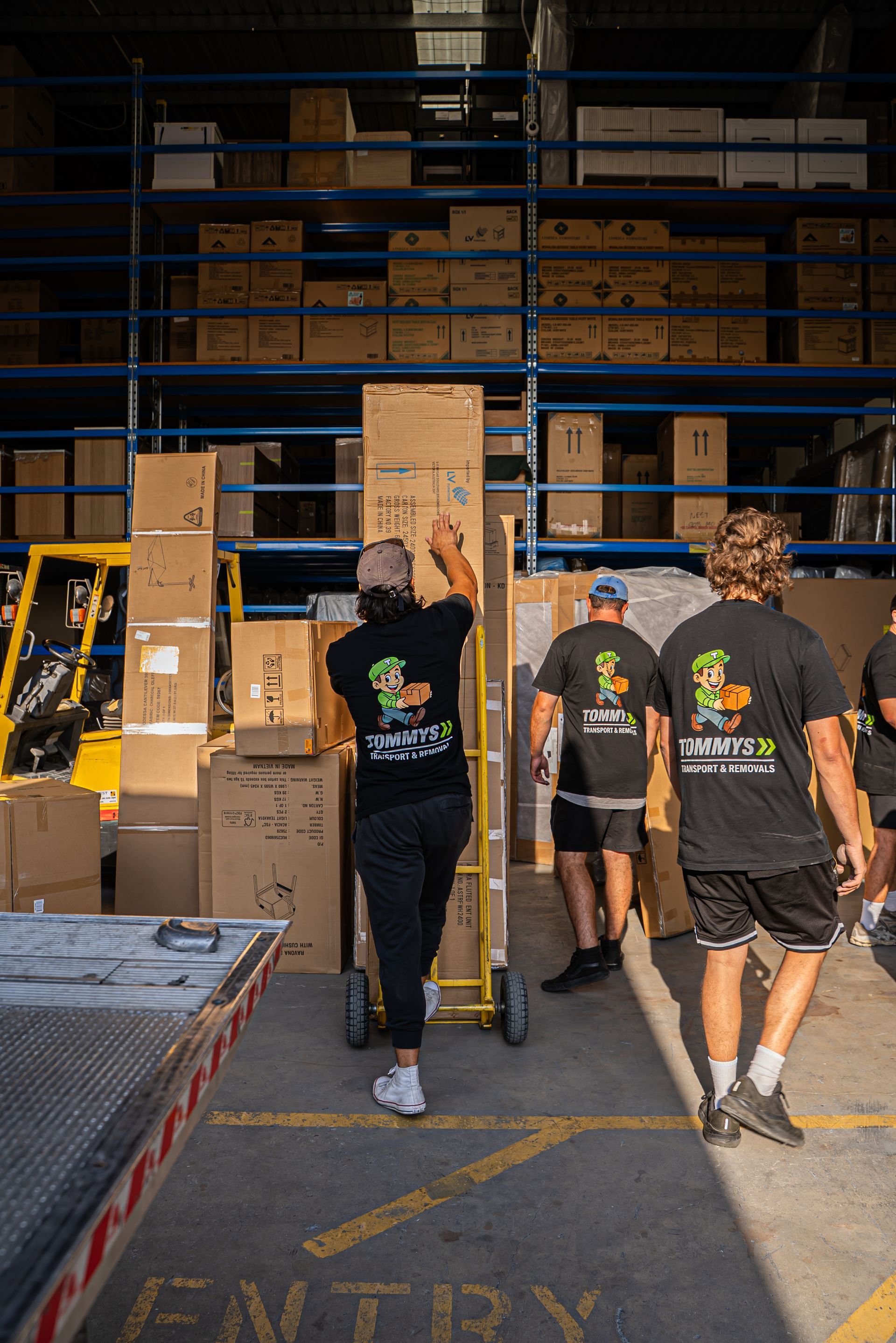 Tommy's Transport & Removals removalist team unloading a removalist truck full of moving boxes
