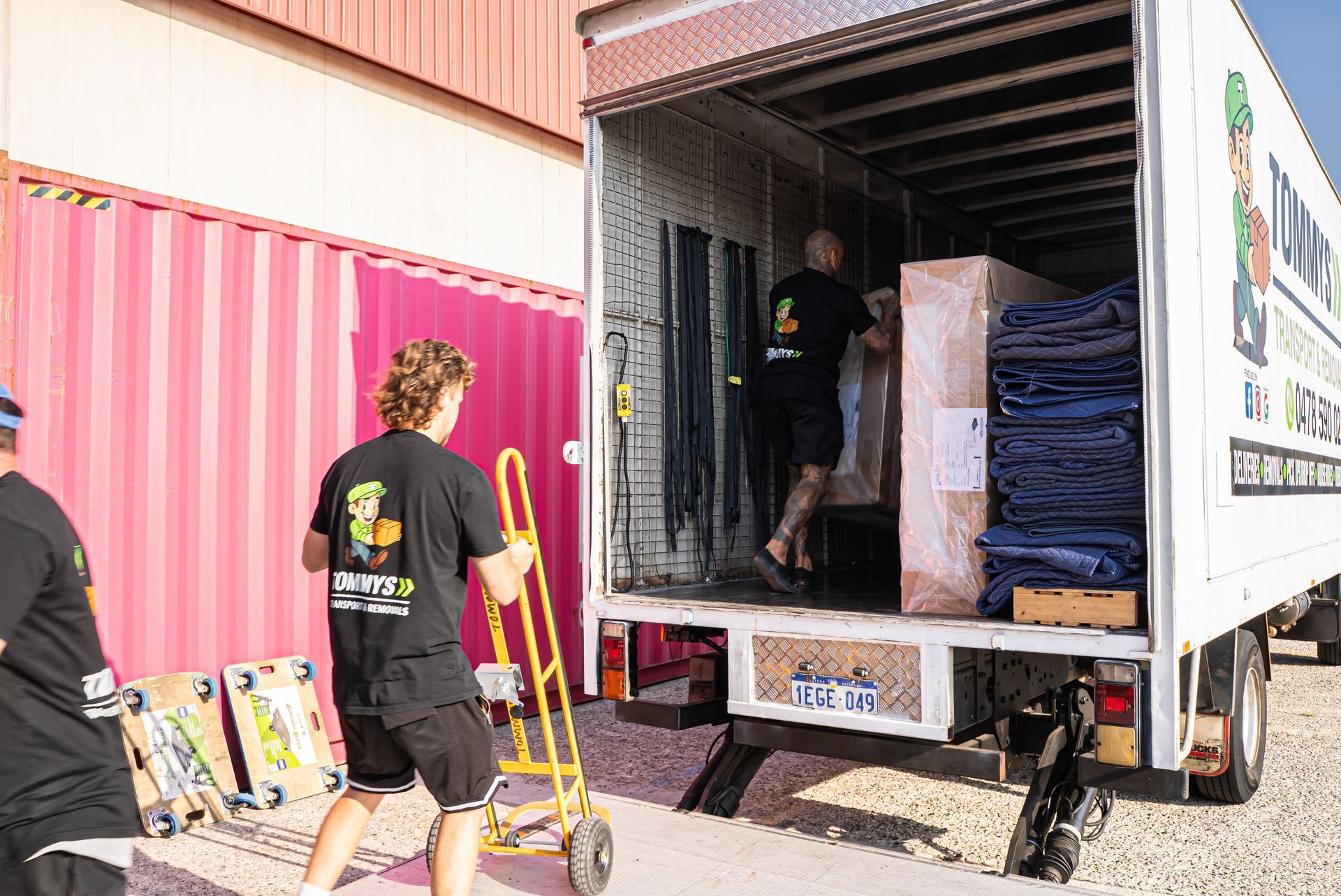 Movers loading a box truck with furniture into removals truck