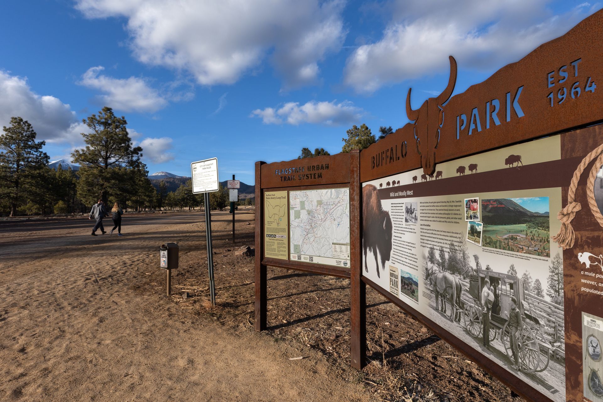 A sign that says park on it in the middle of a dirt field