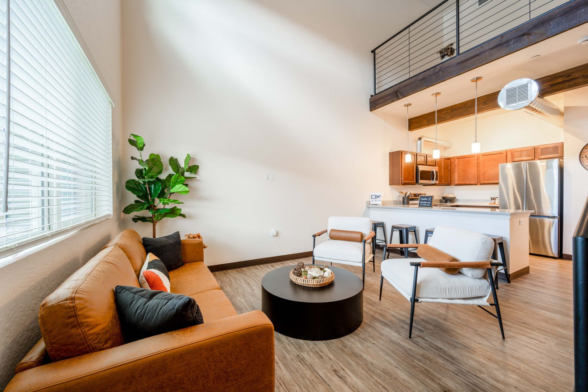 A living room with a couch , chairs , and a coffee table.