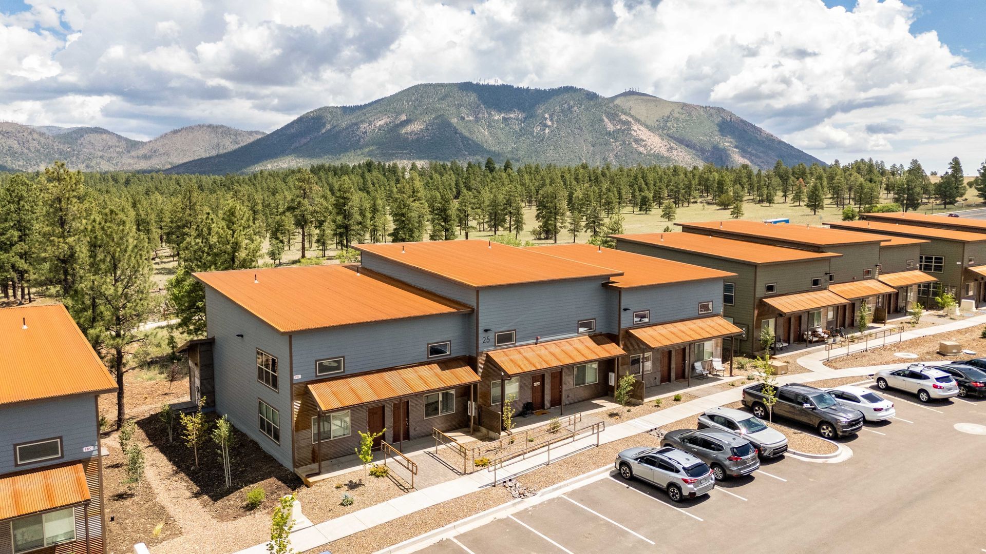 An aerial view of a row of houses with mountains in the background.