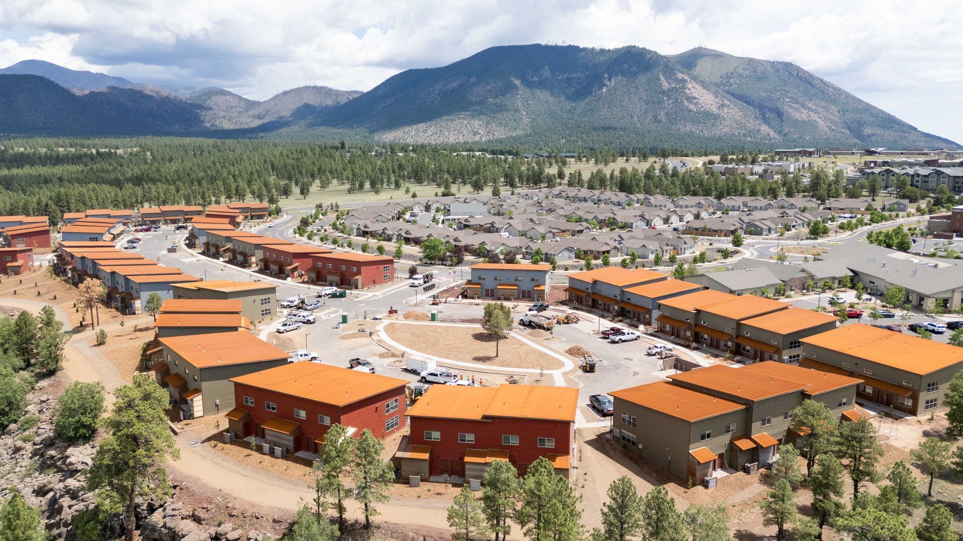 An aerial view of a small town with mountains in the background.