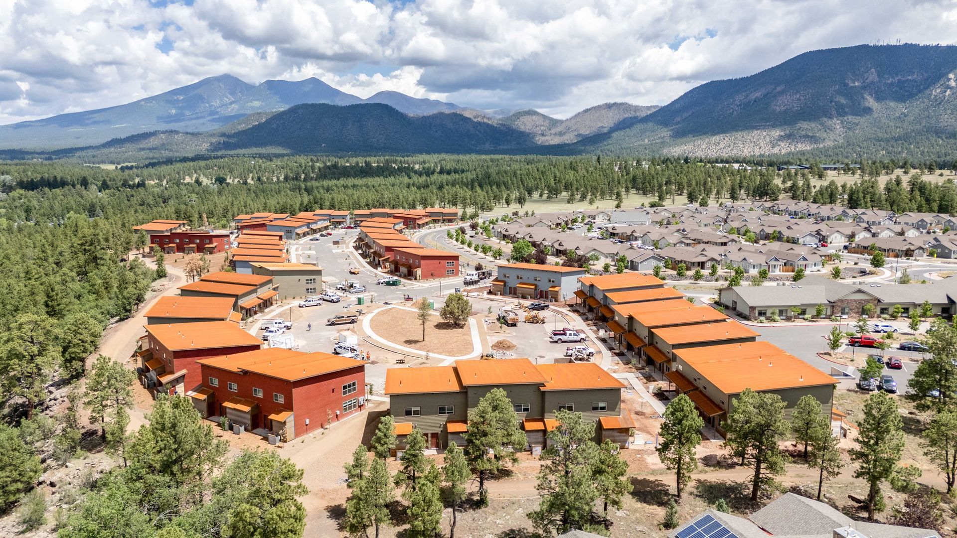 An aerial view of a small town with mountains in the background.