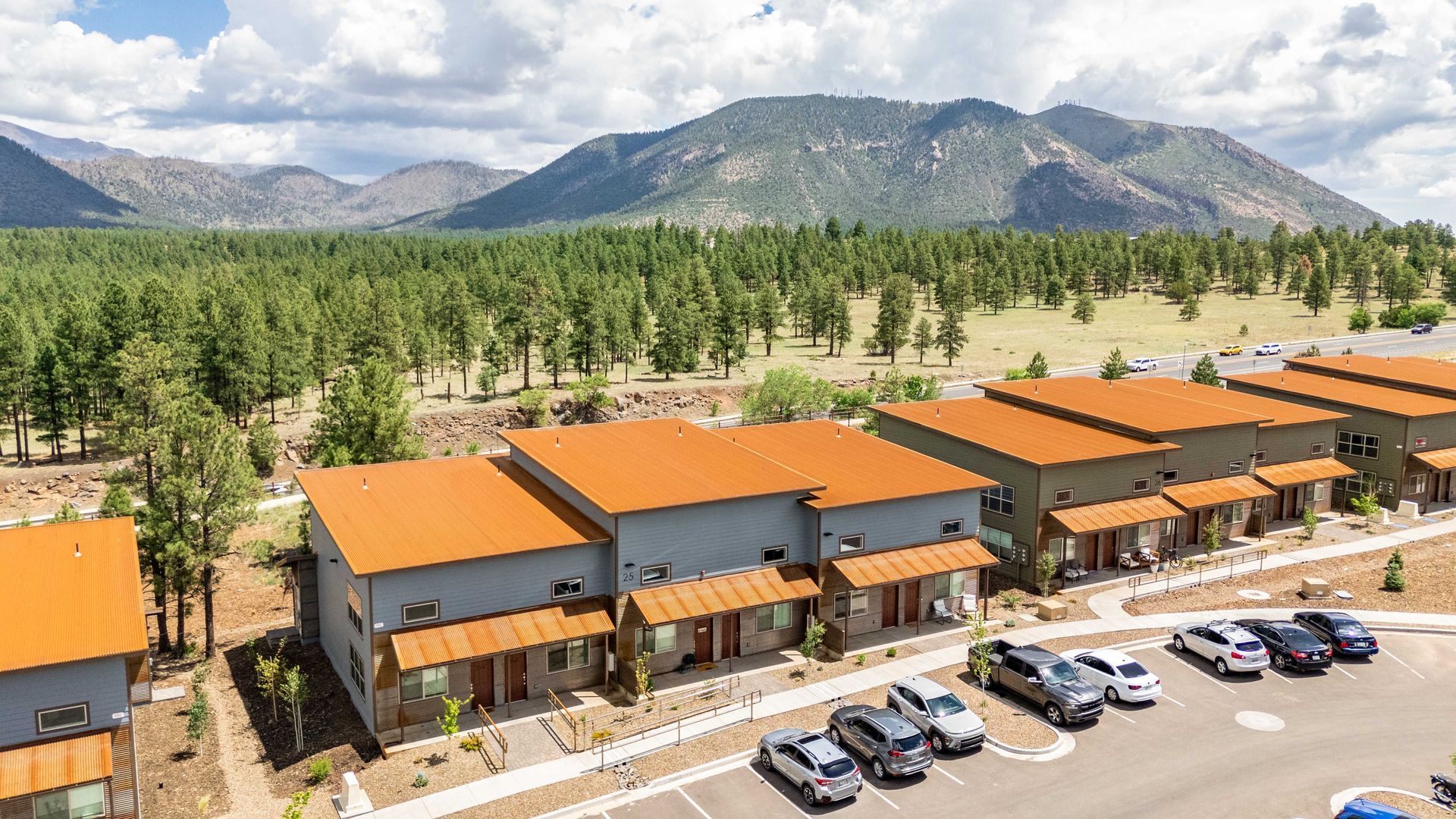 An aerial view of a row of houses with mountains in the background.