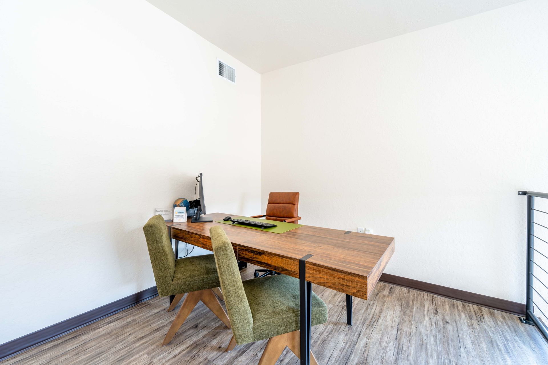 A small office with a wooden desk and chairs.