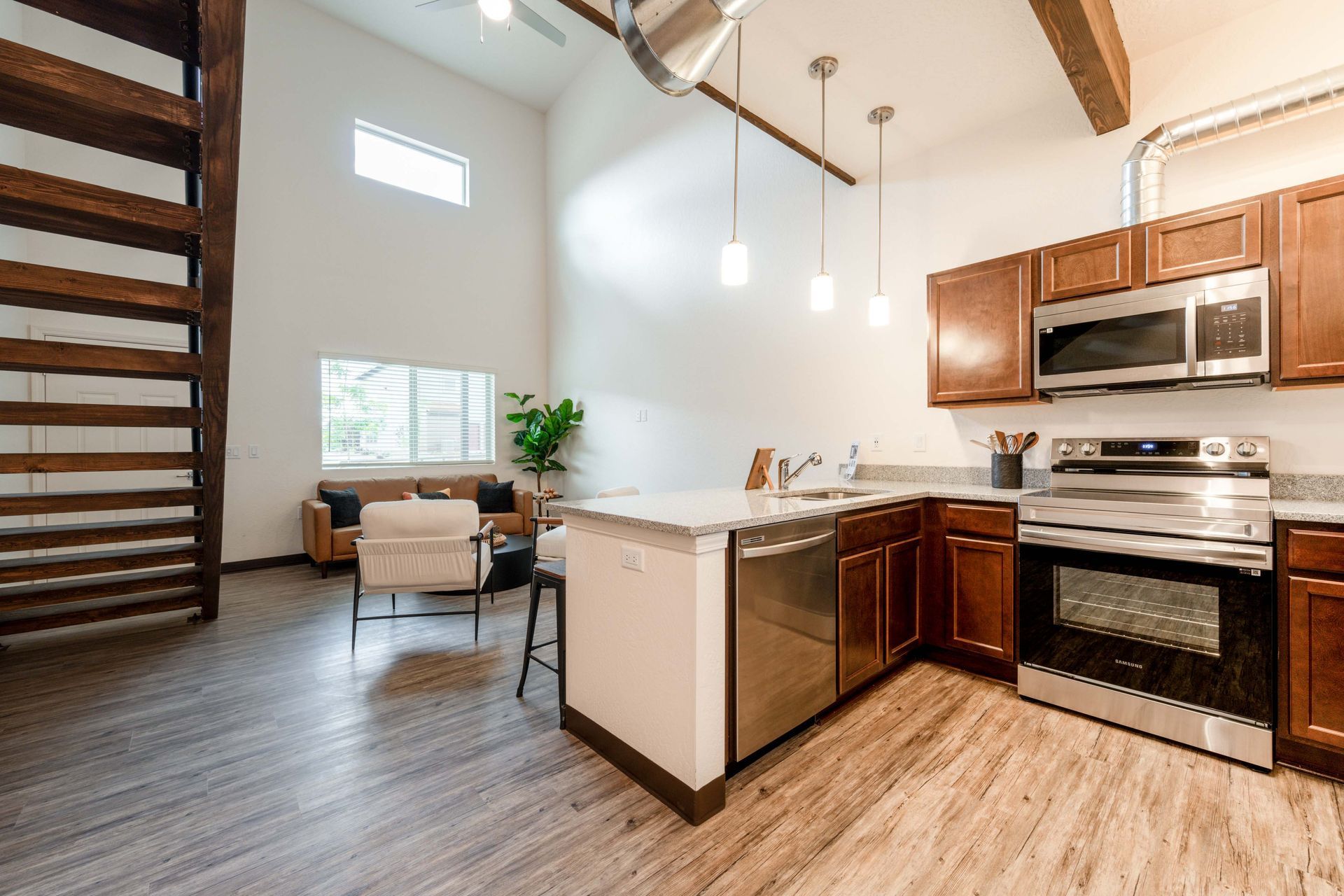 A kitchen with stainless steel appliances and wooden cabinets in a house.