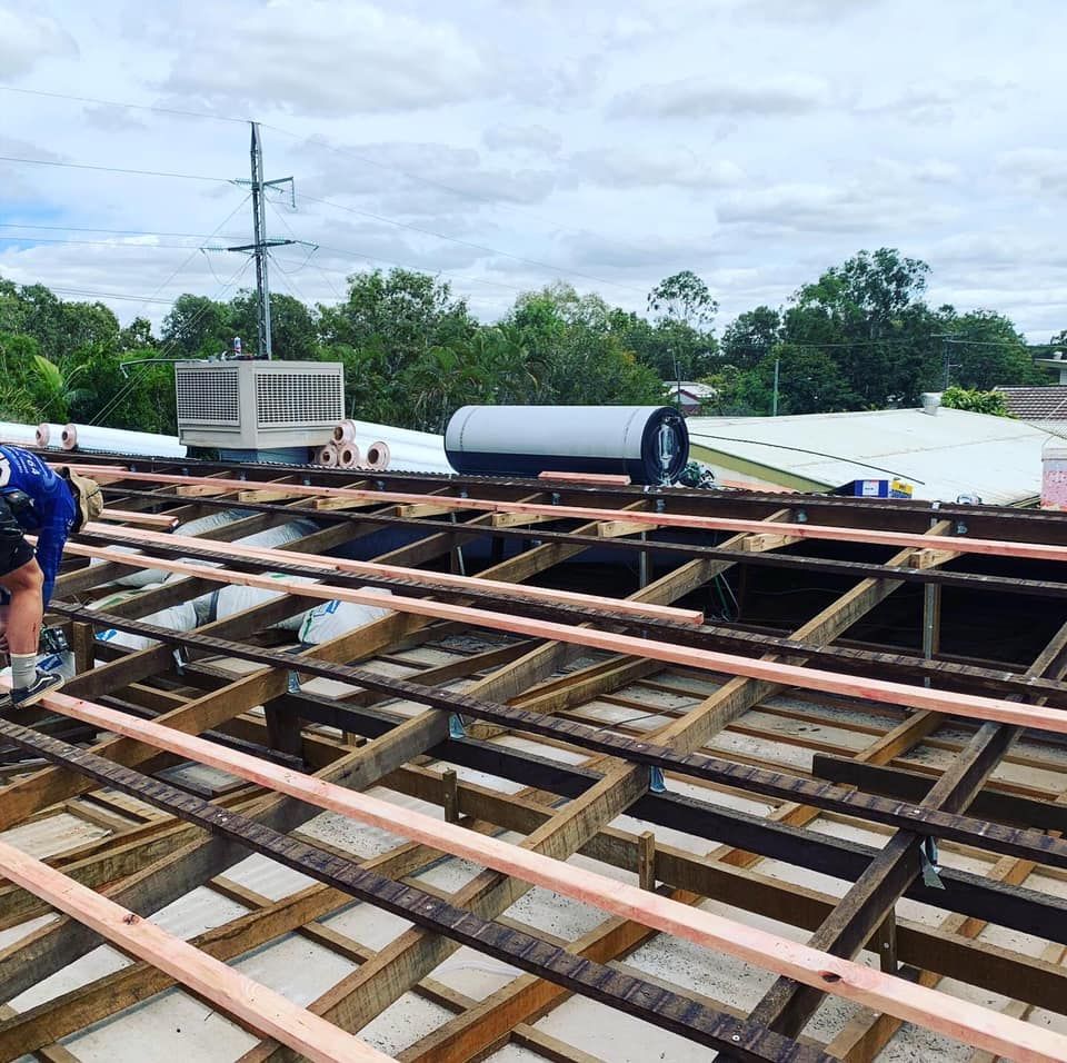 Man working on a roof, installing wooden beams. — Langley Plumbing in Mareeba, QLD