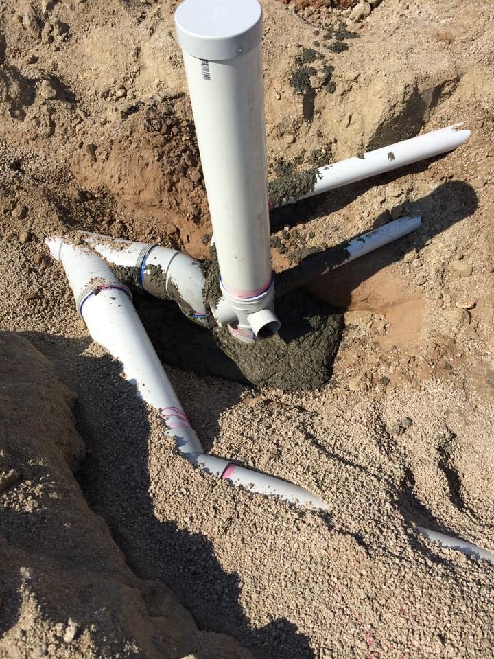PVC pipes connected in a trench, with a vertical pipe and cap — Langley Plumbing in Mareeba, QLD