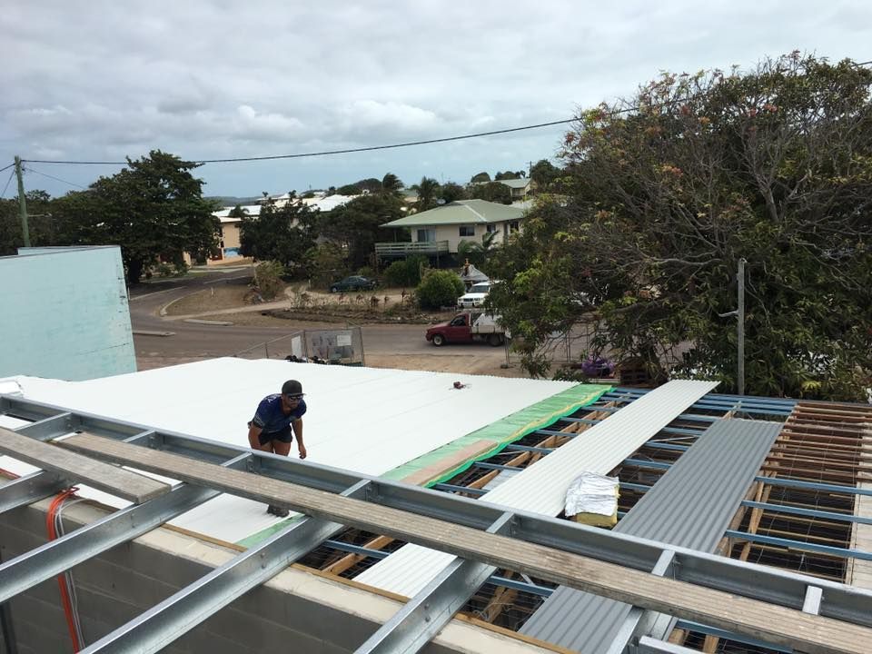 Construction Worker on a Roof Installing Materials — Langley Plumbing in Mareeba, QLD
