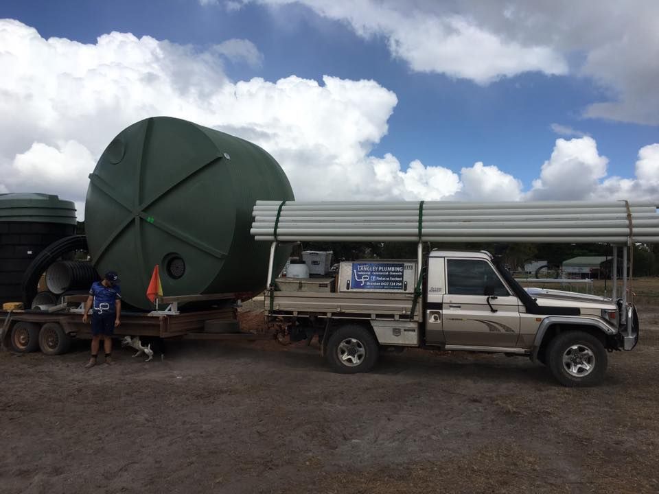 A Large Water Tank on a Trailer and Pipes on a Truck — Langley Plumbing in Mareeba, QLD