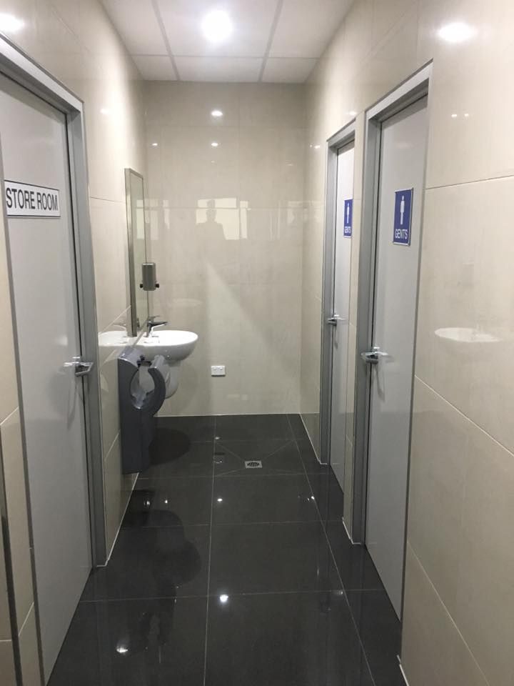 Narrow Hallway With Three Closed Doors, a Sink, and a Black Tile Floor — Langley Plumbing in Mareeba, QLD