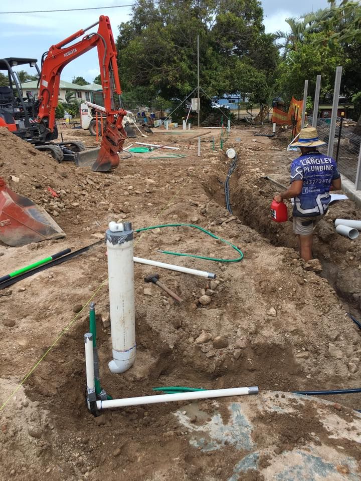 Construction Site With Excavator and Plumber Working on Pipes in Trench — Langley Plumbing in Mareeba, QLD