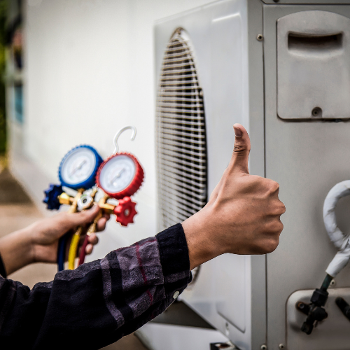 A person is giving a thumbs up in front of an air conditioner