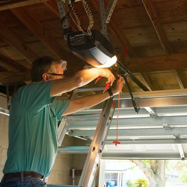 Garage Door Repairs — Man Fixing Garage Door Opener in Glendale Heights, IL