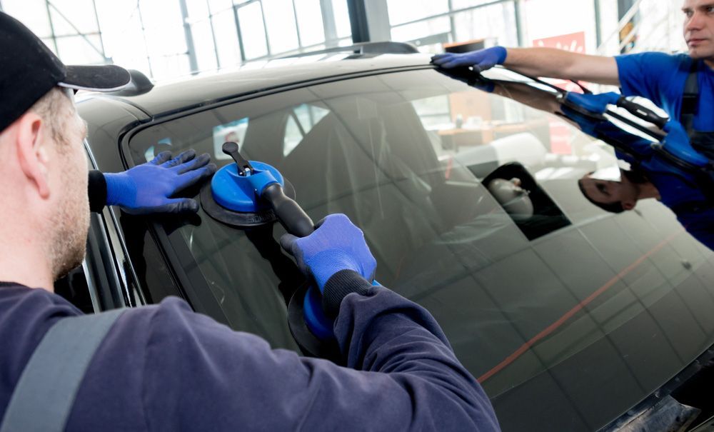 Workers Preparing to Lift Windscreen Off a Car — ADAS Services in the Southern Highlands, NSW