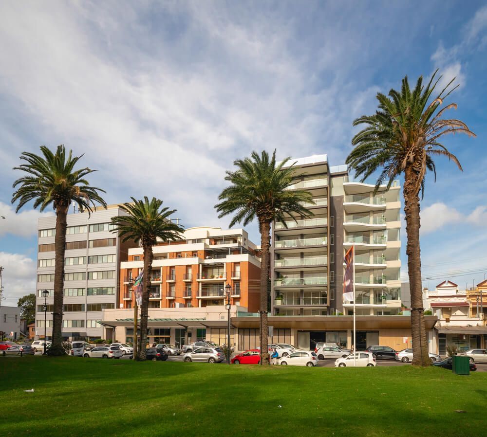 A Row of Tall Buildings with Palm Trees in Front of Them — ADAS Calibration Pty Ltd in Mascot, NSW
