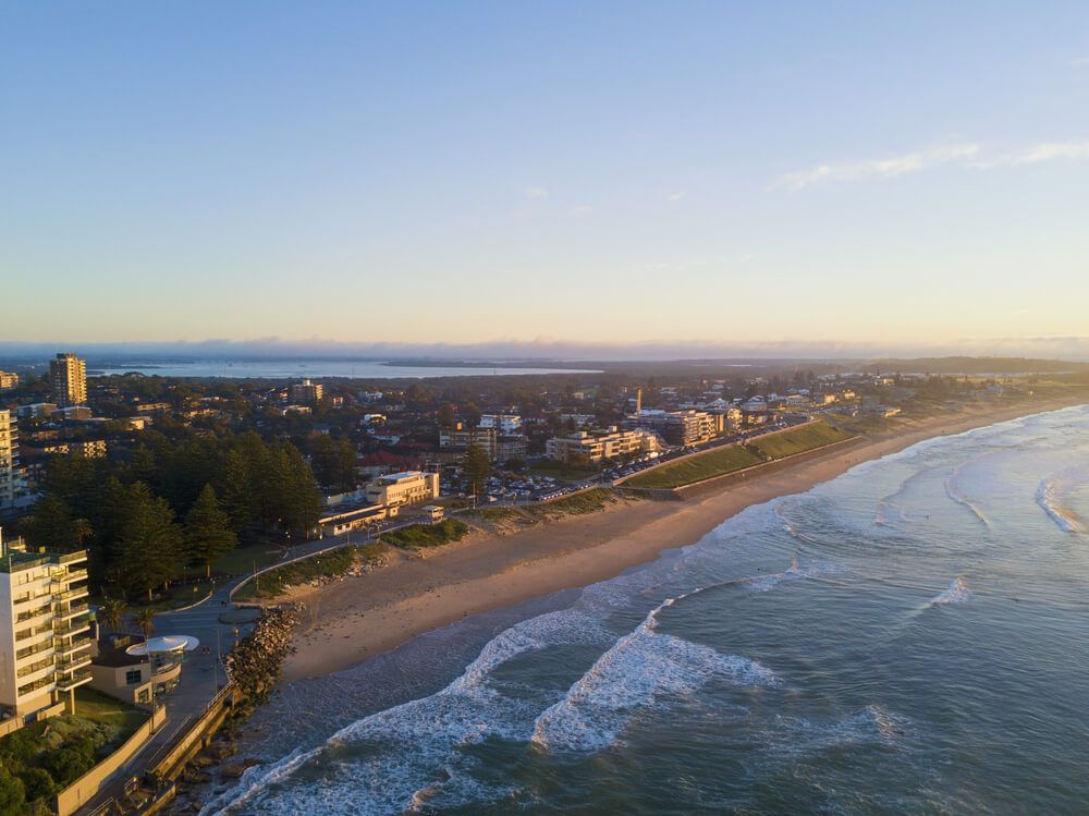 An Aerial View of A City and A Beach at Sunset — ADAS Calibration Pty Ltd in Sutherland, NSW