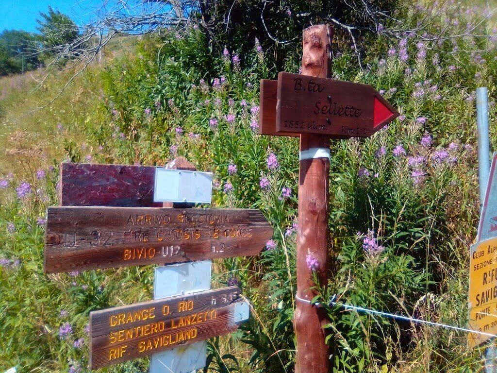 Un cartello di legno con una freccia rossa che punta a destra