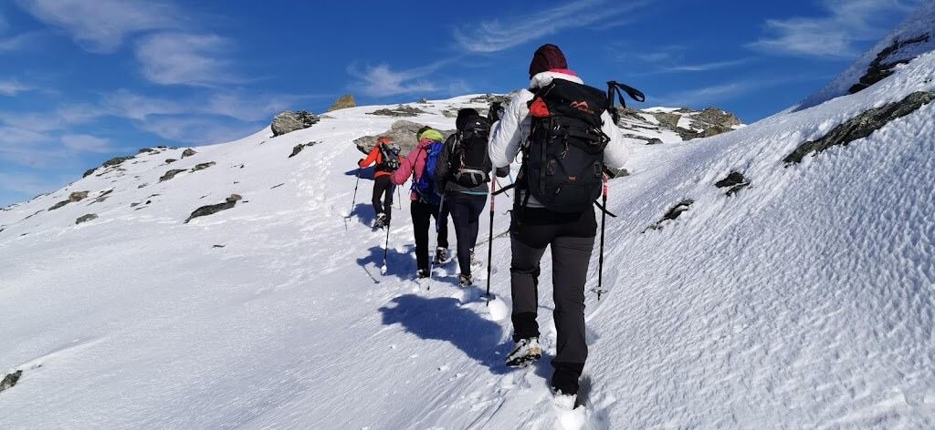 Un gruppo di persone sta scalando una montagna coperta di neve.