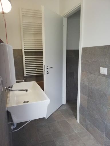 Un bagno con lavandino, portasciugamani e porta.