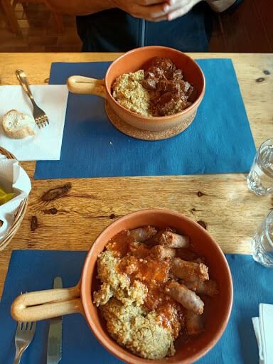 Due ciotole di cibo sono appoggiate su un tavolo di legno.