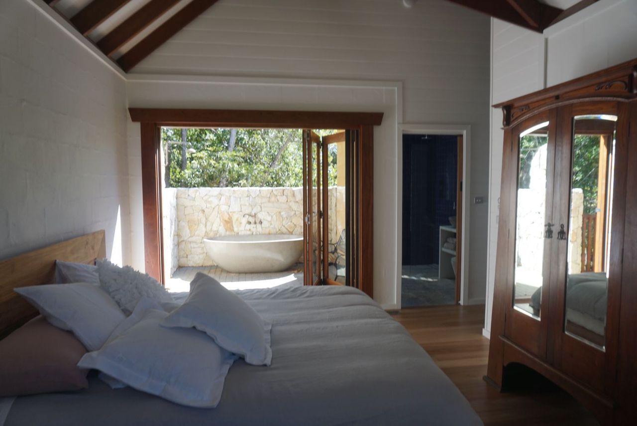 A bedroom with a large bed and a bathtub