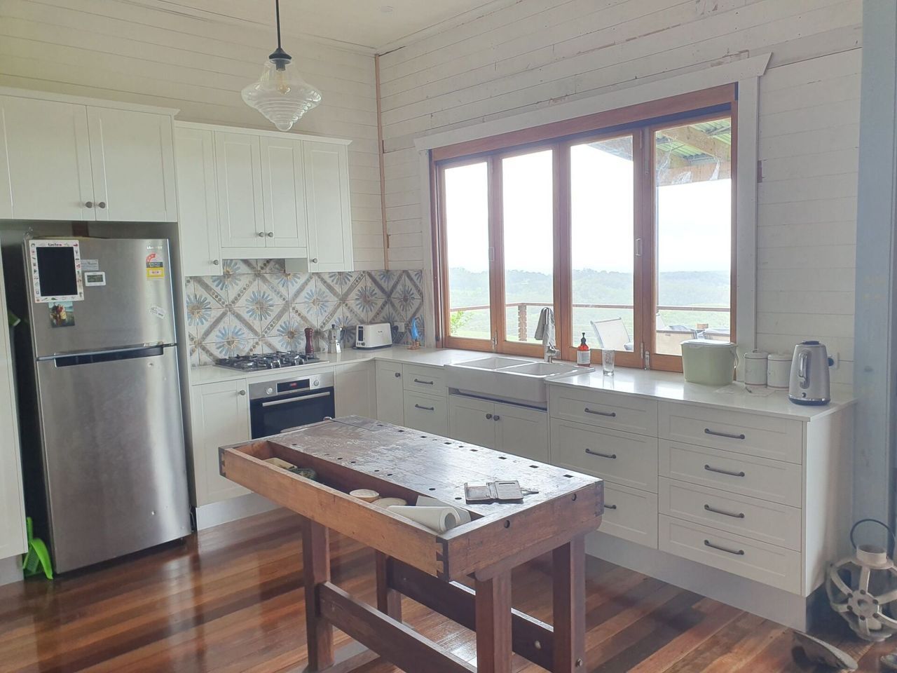 A kitchen with white cabinets and a stainless steel refrigerator