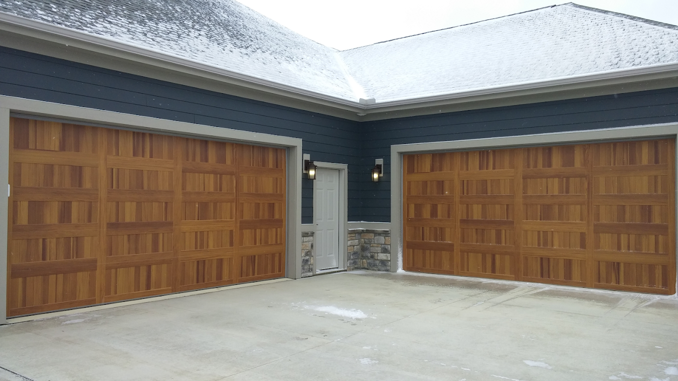 There are two garage doors on the side of a house.