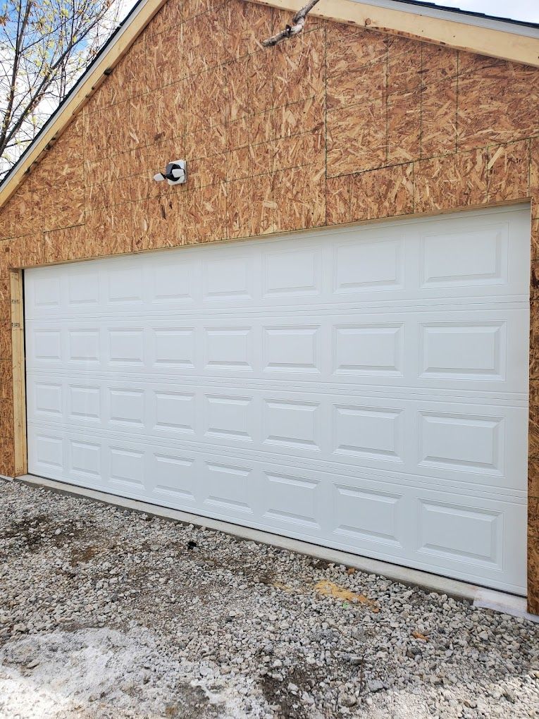 A white garage door is installed on the side of a house.