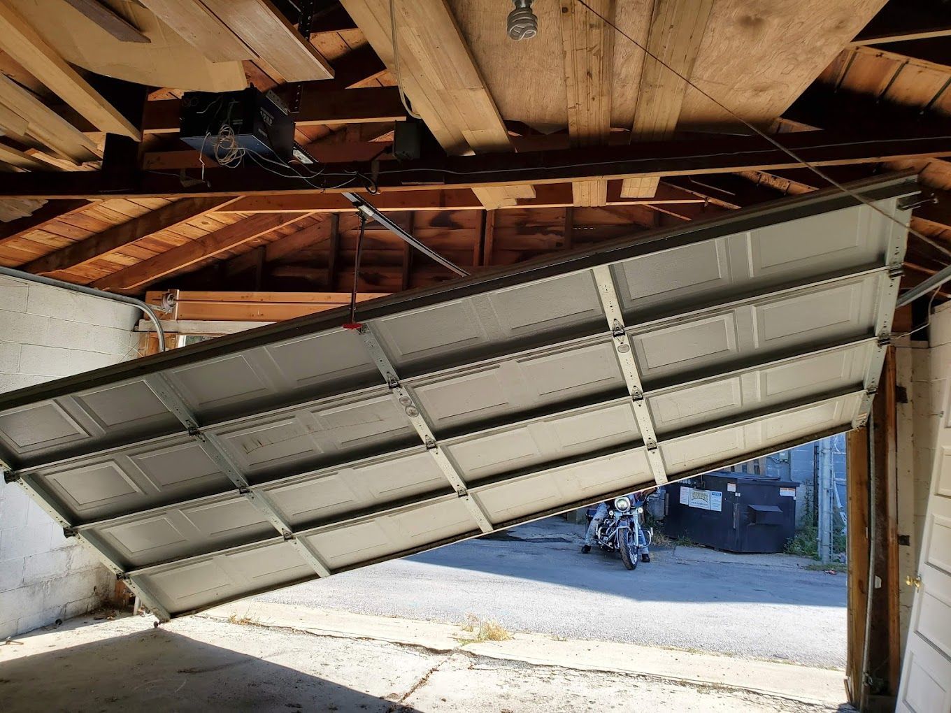 A garage door is open and hanging from the ceiling.