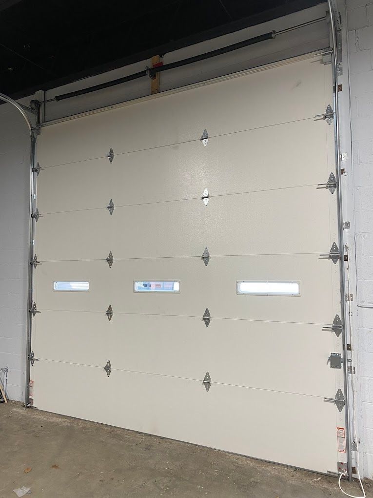 A white garage door is open in a garage.