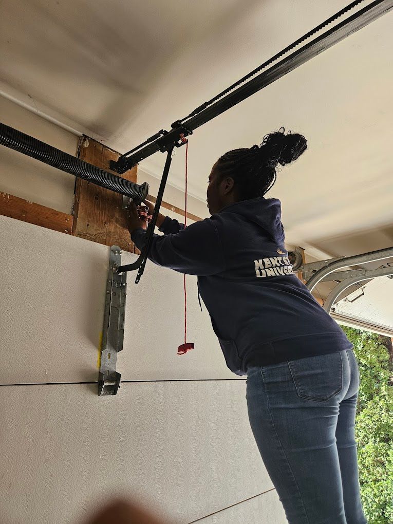 A woman is working on a garage door opener.
