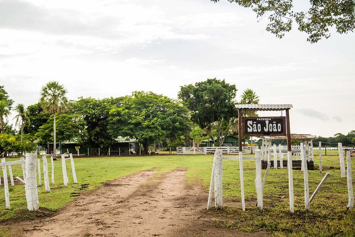 Uma estrada de terra que leva a uma fazenda com uma placa que diz senhor jiji