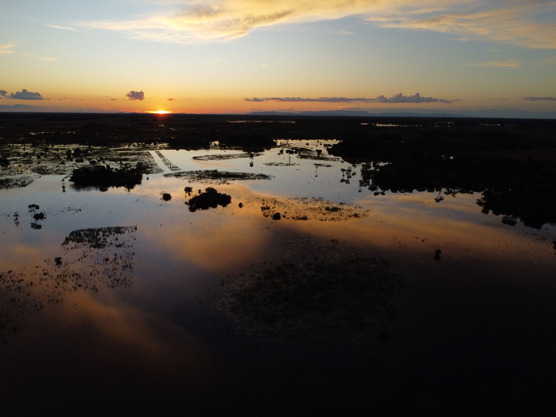 Uma vista aérea de uma área inundada ao pôr do sol