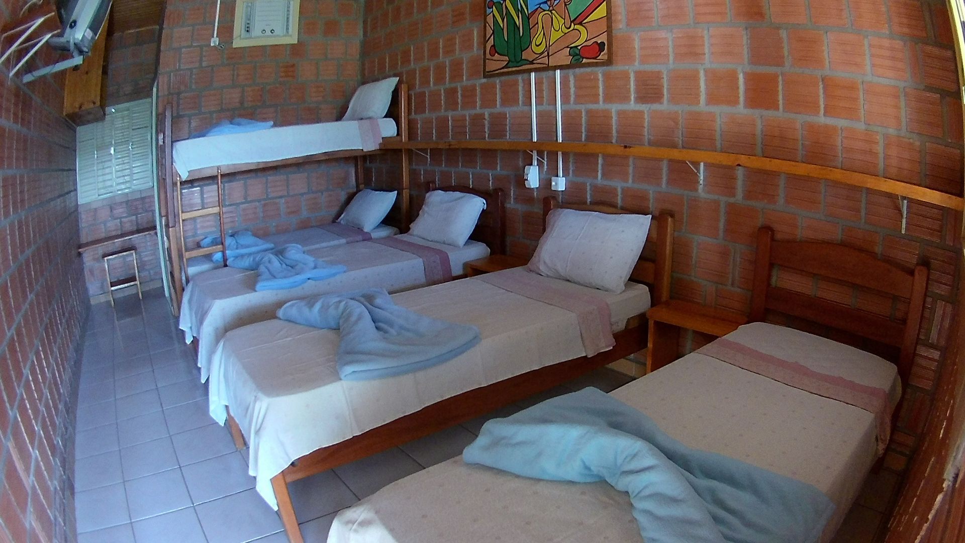 Um quarto com três camas e um beliche.