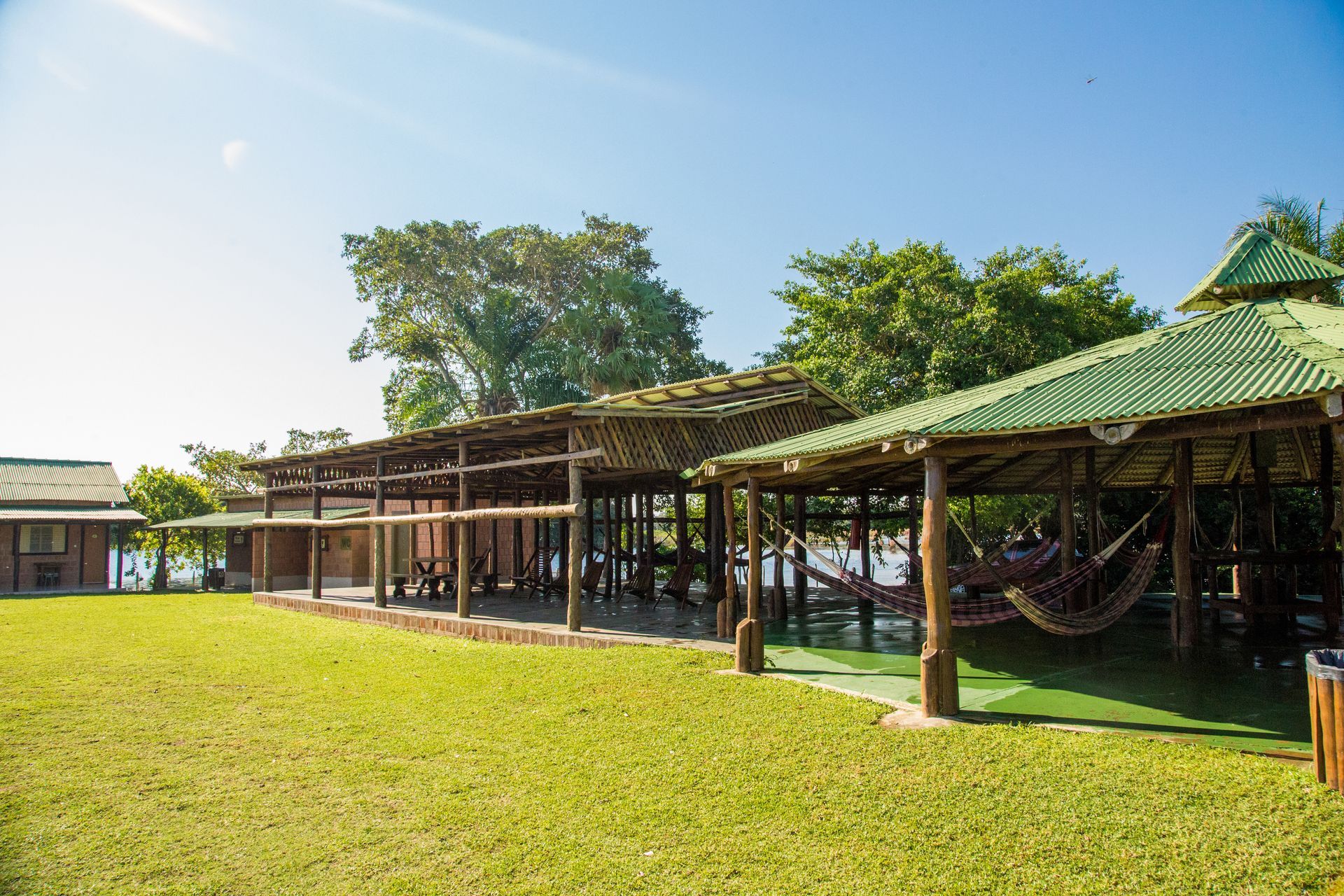 Um campo verdejante com uma fileira de construções de madeira e redes.