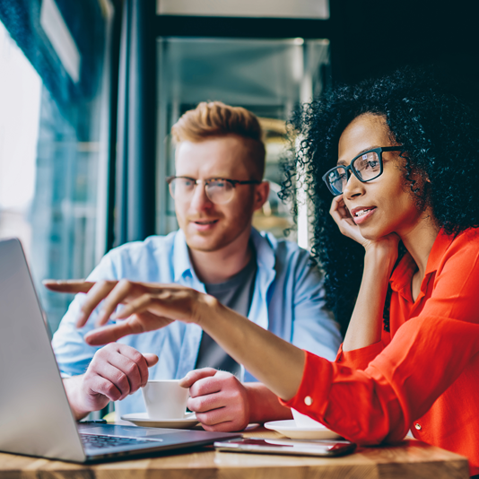 Image of two people looking at a laptop