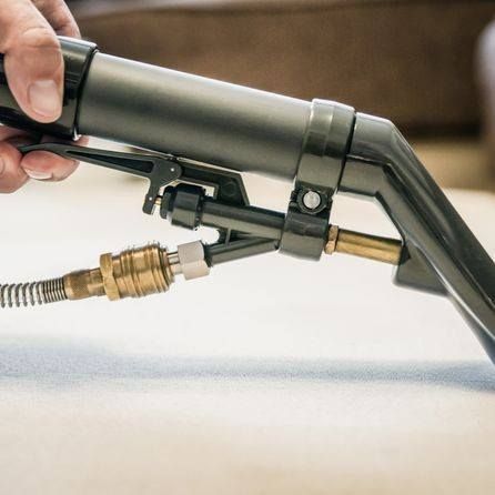 a person is holding a vacuum cleaner with a hose attached to it .