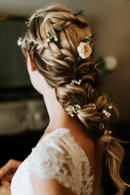 Stylist pinning up a bride's hairstyle before the wedding