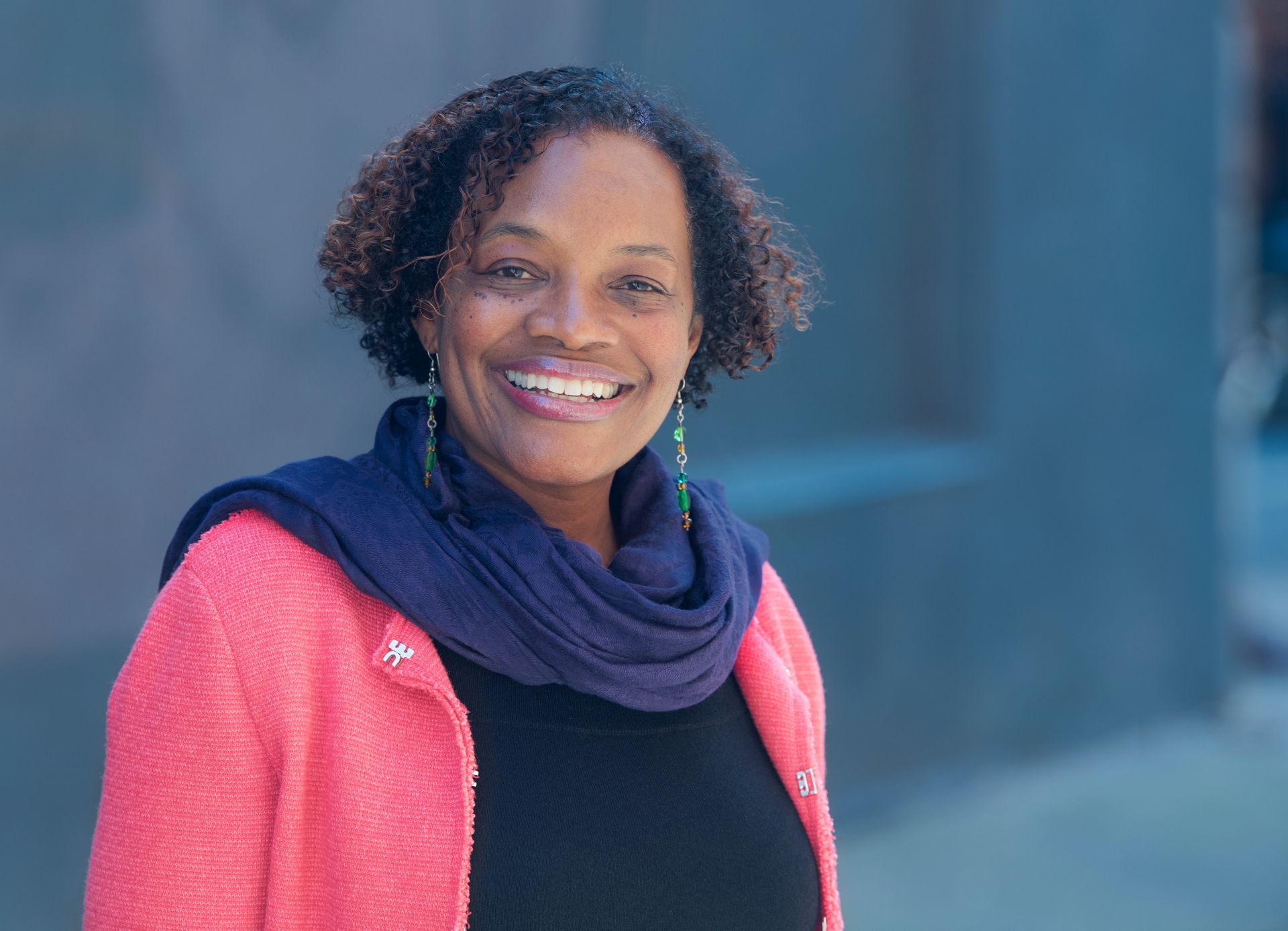 headshot of singer susan brown smiling at camera wearing pink jacket