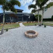There is a fire pit in the middle of the yard in front of a house.
