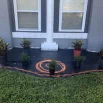 A wooden deck with potted plants on it in front of a house.