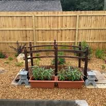 There is a wooden bridge in the middle of the garden.