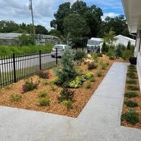 A walkway leading to a house with a garden in front of it.